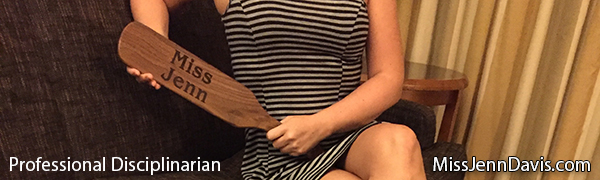 Professional Disciplinarian holding a paddle, Miss Jenn Davis lap photo, Femdom