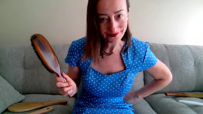 Strict Disciplinarian Miss Jenn holding a brush