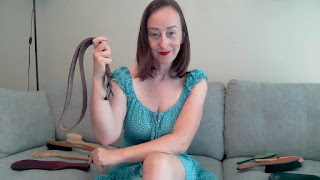 Professional Disciplinarian Miss Jenn Davis holding the belt